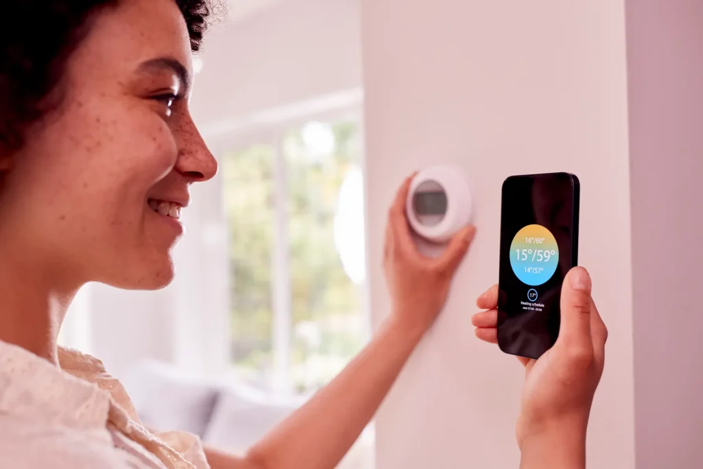 woman using smart thermostat