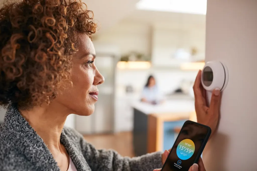 woman using smart home thermostat